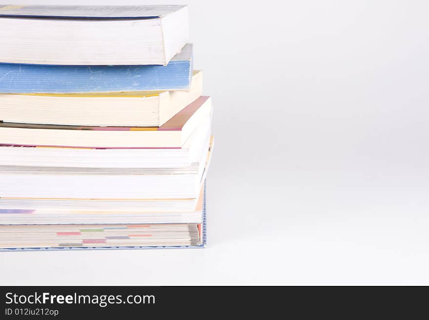 Stack of many books on the white background. Stack of many books on the white background