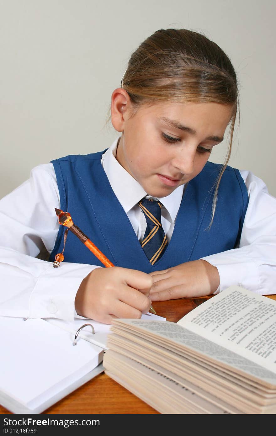 Teenage School girl busy with her homework, wearing uniform