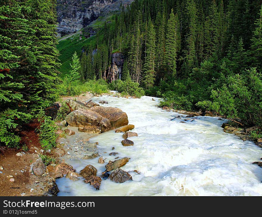 Fast moving river in the Canadian Rockies after a hard rain.  The little stream turned into rapids. Fast moving river in the Canadian Rockies after a hard rain.  The little stream turned into rapids.