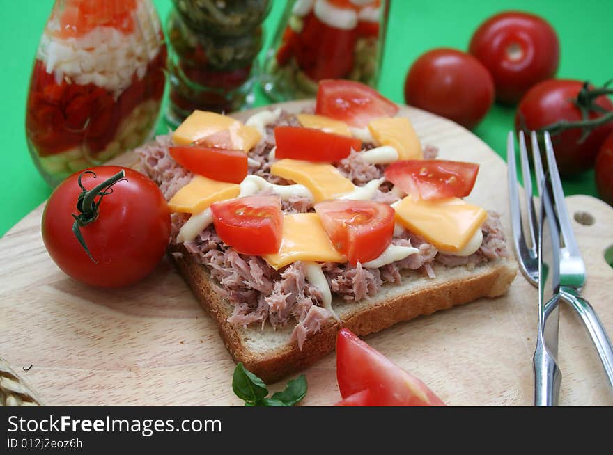 A snack of bread with fish and cheese