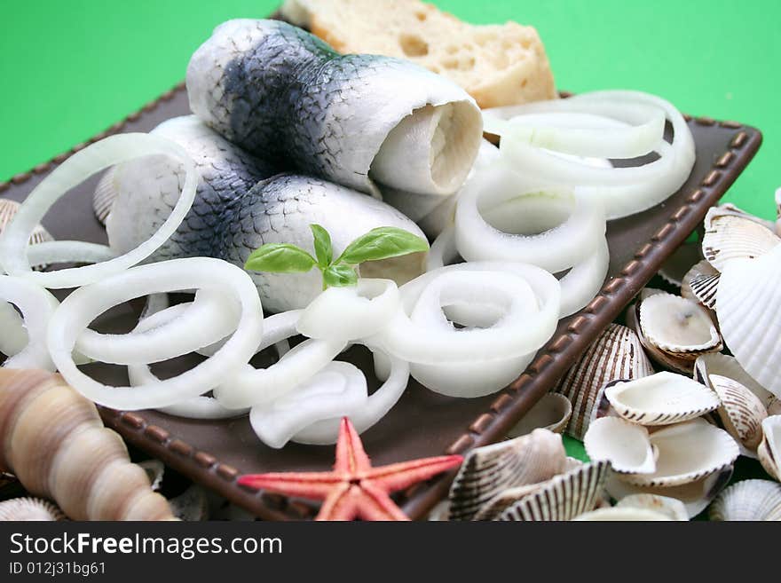 Some rolls of fresh fish on a plate with onions