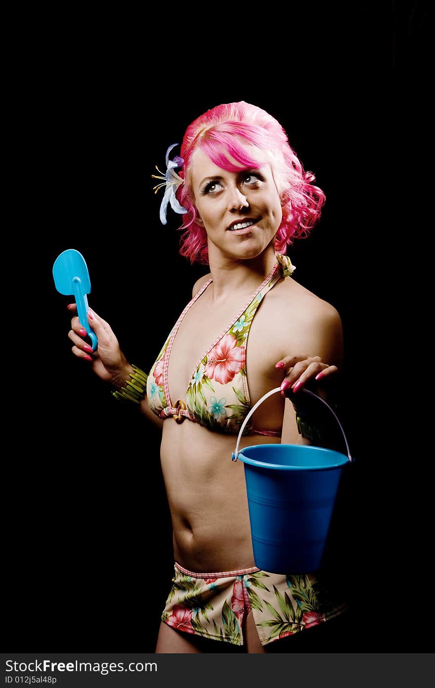 Young woman on a black background holding beach toys. Young woman on a black background holding beach toys