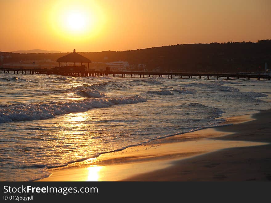 Sunrise on the beach by beach umbrellas and lounge