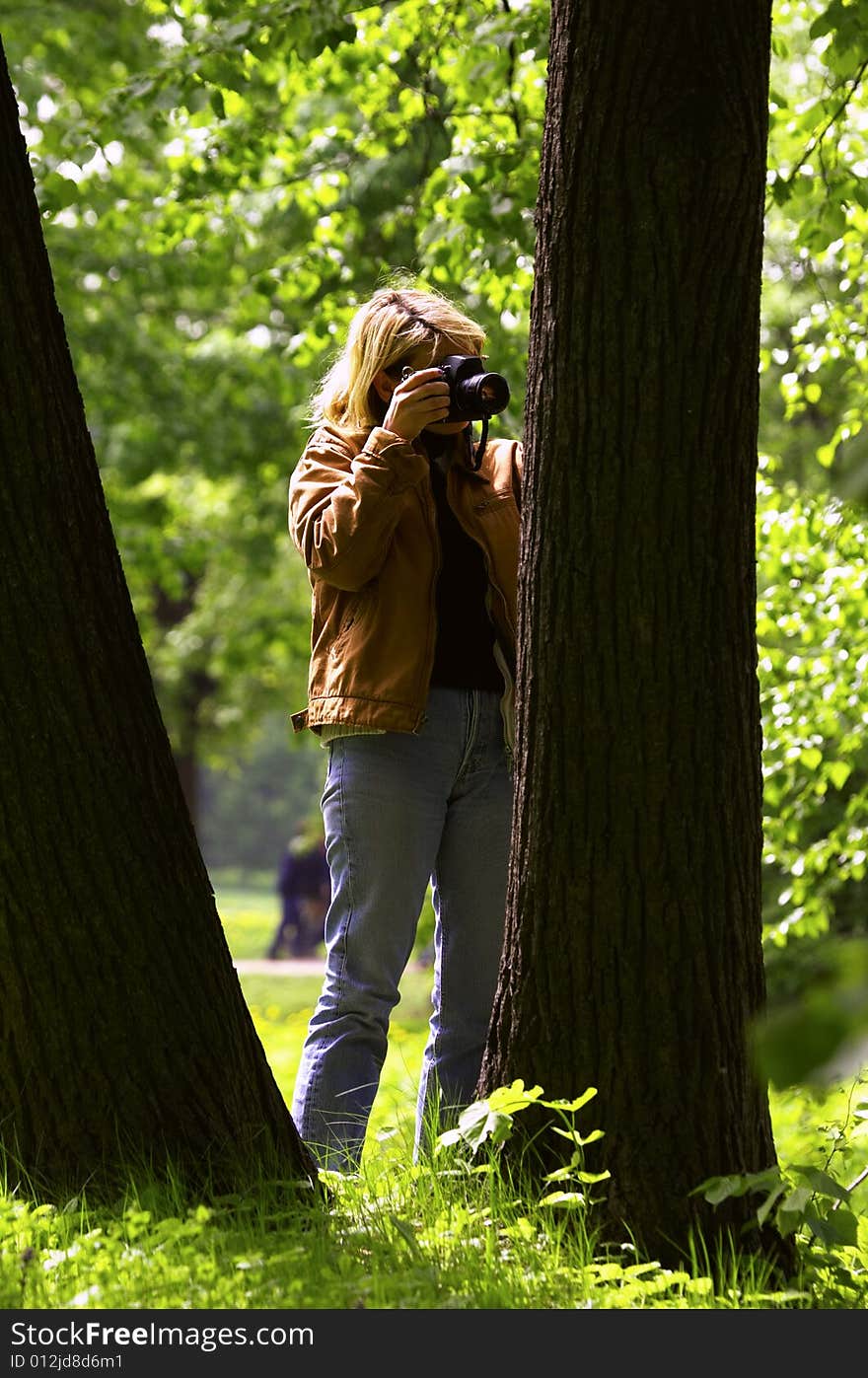 Woman photographer shooting a leaf on a tree