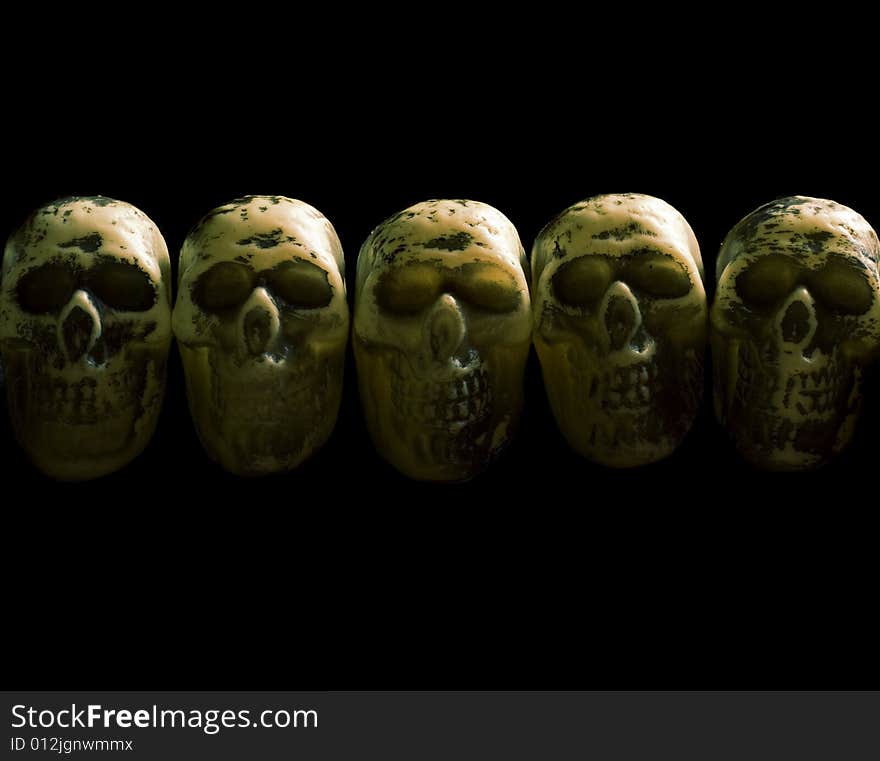 A row of five skulls on isolated black. A row of five skulls on isolated black.