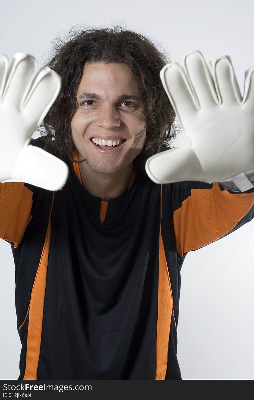 Soccer goalie smiles as he holds his hands up.  Vertically framed photograph. Soccer goalie smiles as he holds his hands up.  Vertically framed photograph