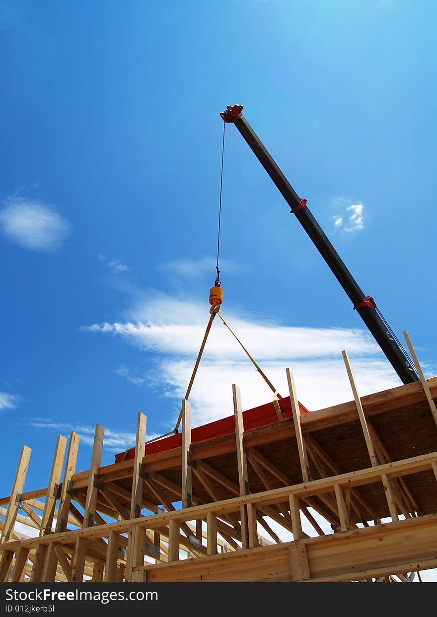 A crane moves wood on a construction site. A crane moves wood on a construction site