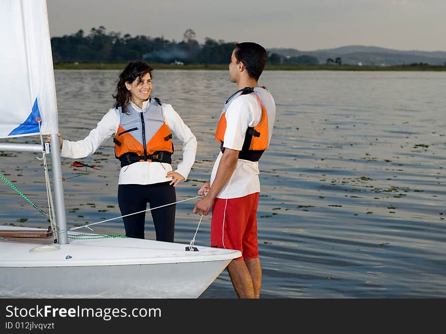 Couple Standing Next to Sailboat - Horizontal