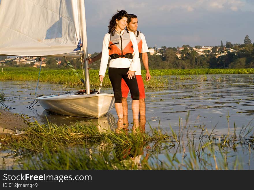 Couple Next To Sailboat On Water - Horizontal