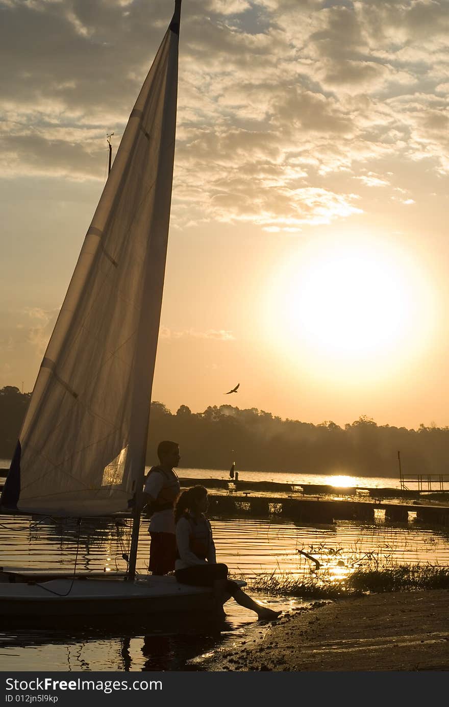 Man and Woman Standing Next to Sailboat - Vertical