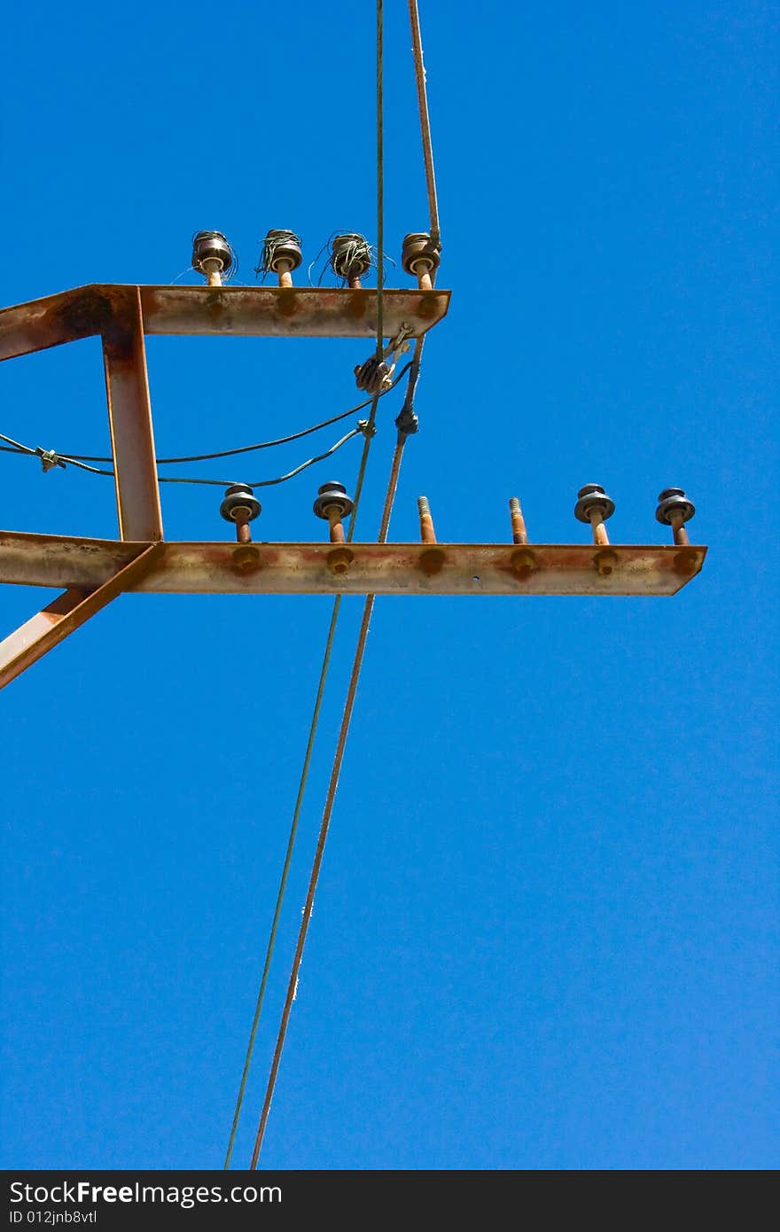 Electrical wiring and insulators against a blue sky. Electrical wiring and insulators against a blue sky