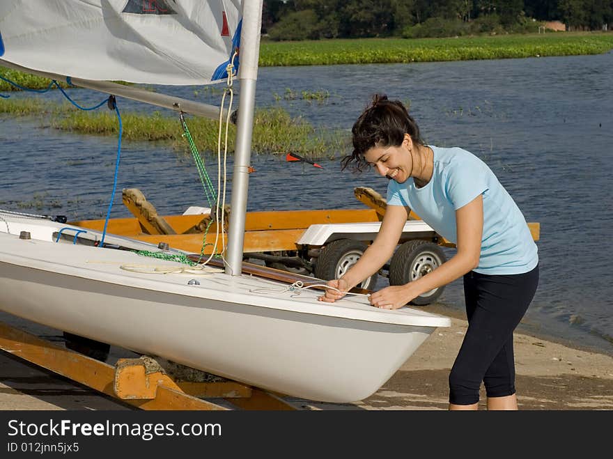 Woman Fixing Sail on Sailboat - Horizontal