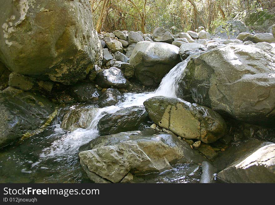 A short waterfall surrounded by stones.