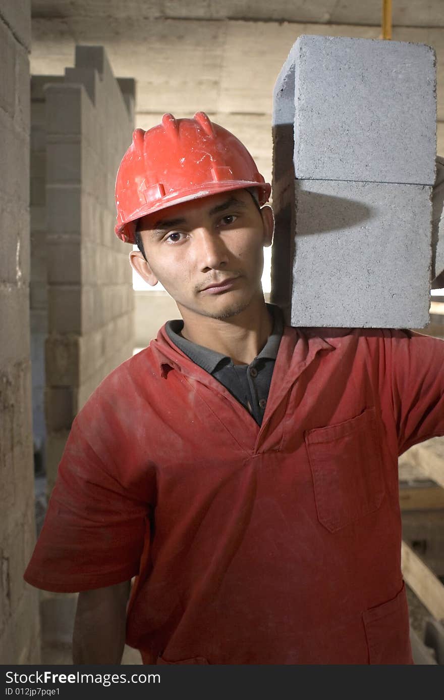 Construction worker wearing orange suit looks into camera. Vertically framed photo. Construction worker wearing orange suit looks into camera. Vertically framed photo.