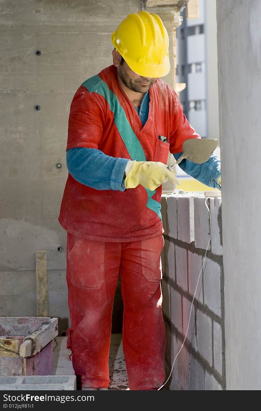 Worker Builds Cinder Block Wall - Vertical