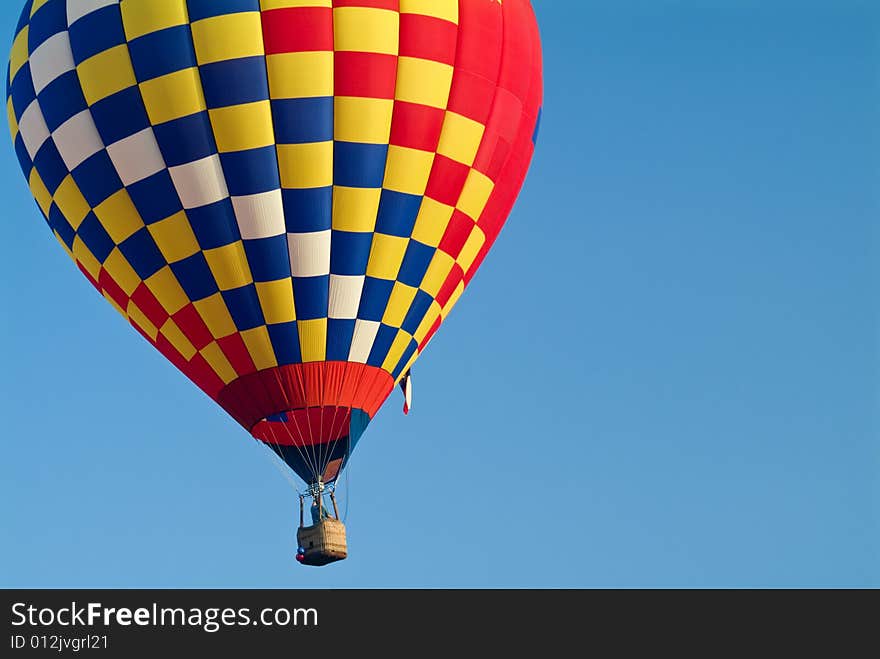 A colorful hot air balloon floating in a bright blue sky. A colorful hot air balloon floating in a bright blue sky.