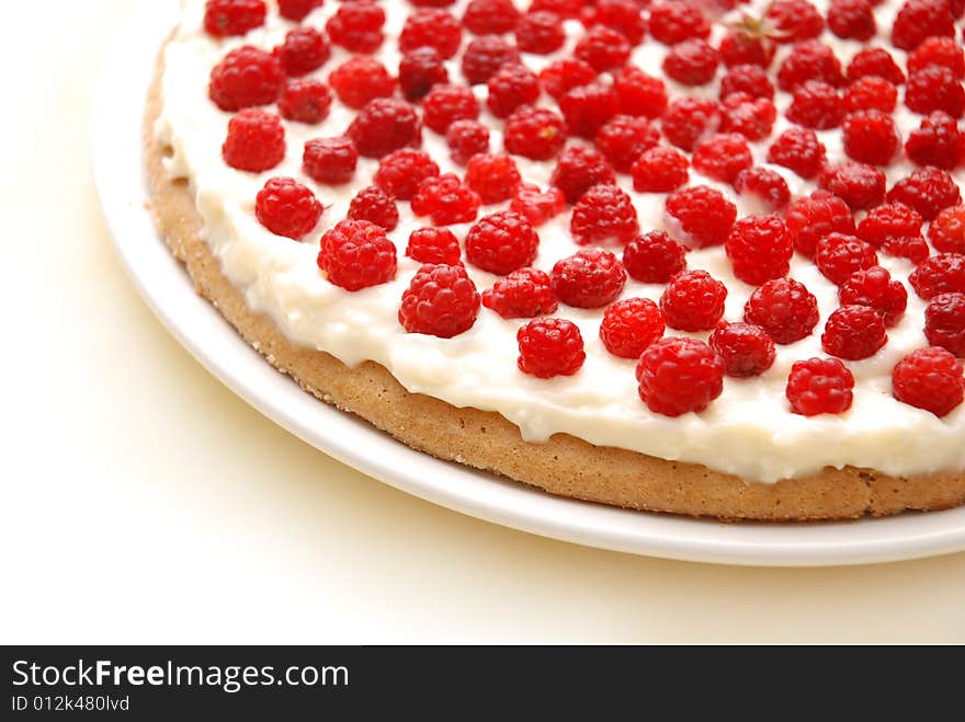 Appetizing raspberry tart on white plate.