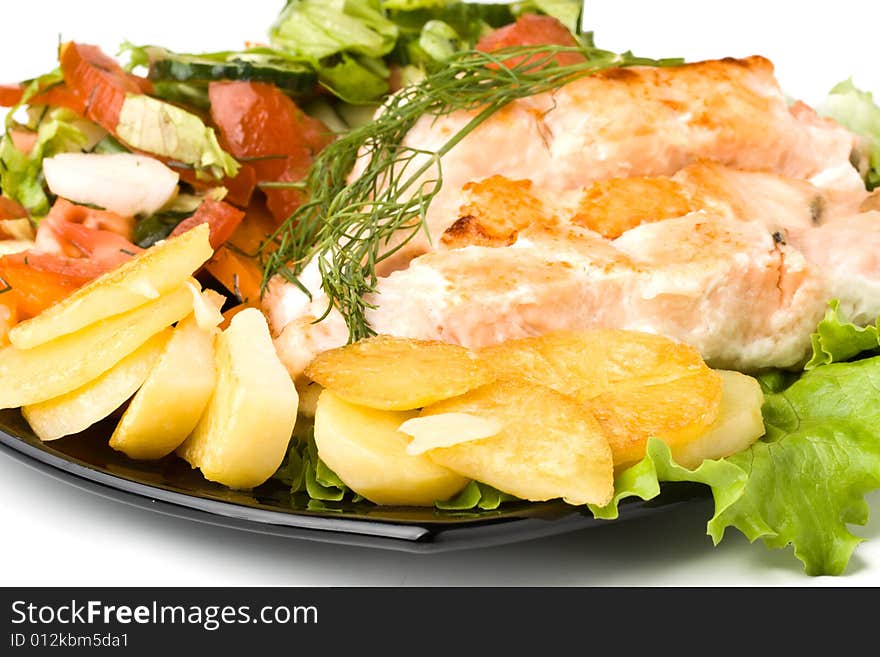 Stake from a salmon with vegetables on a plate. Closeup.