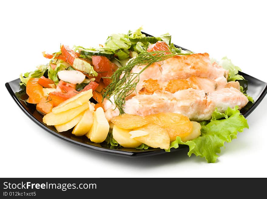 Stake from a salmon with vegetables on a plate. Closeup.