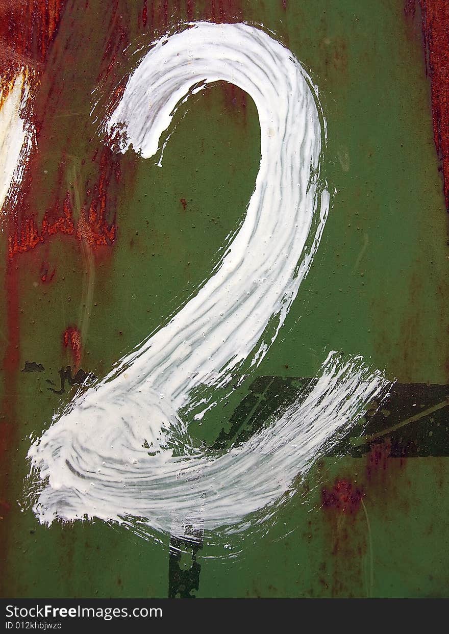 The figure two is drawn by a white paint on a rusty metal background.