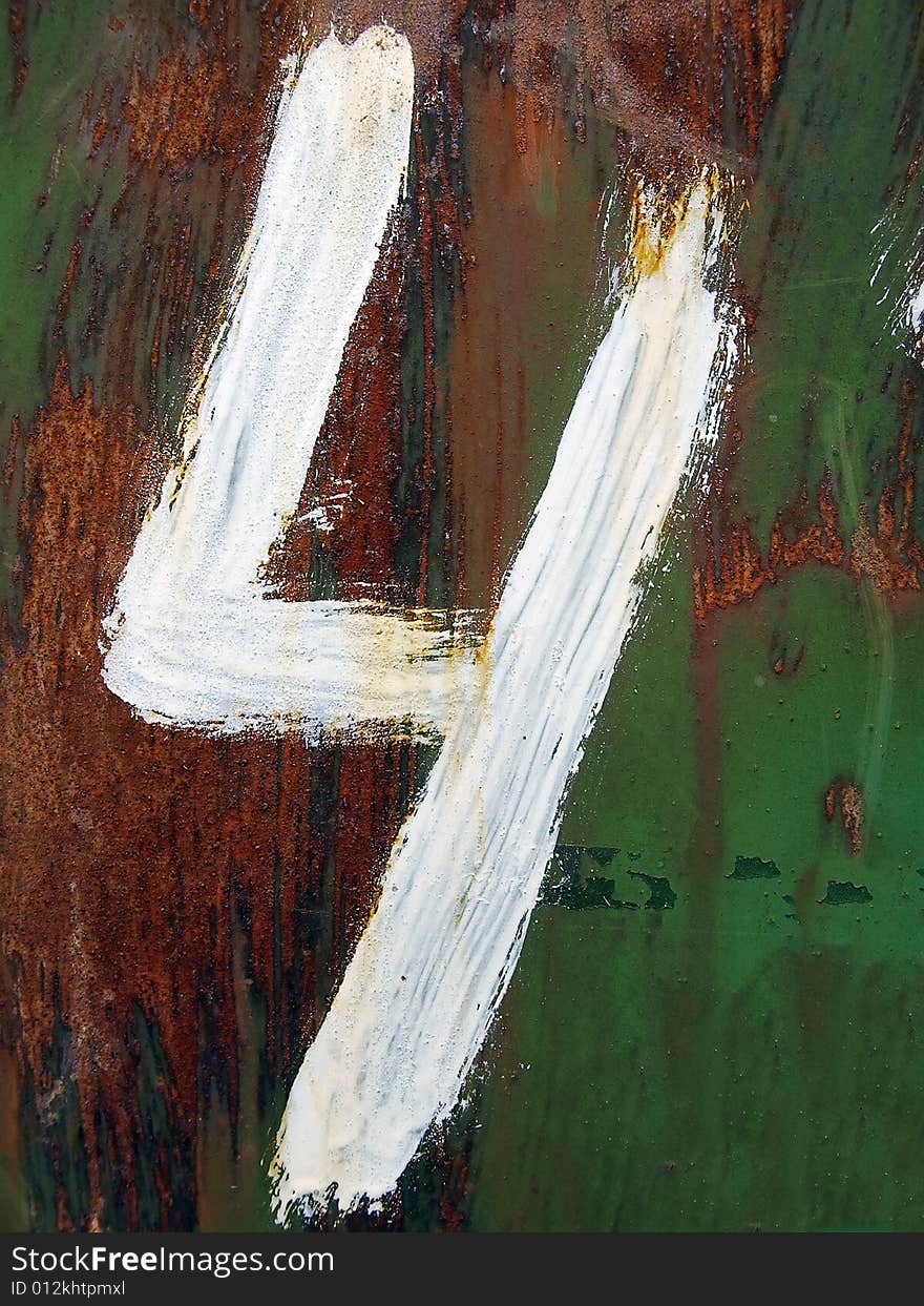 The figure four is drawn by a white paint on a rusty metal background.