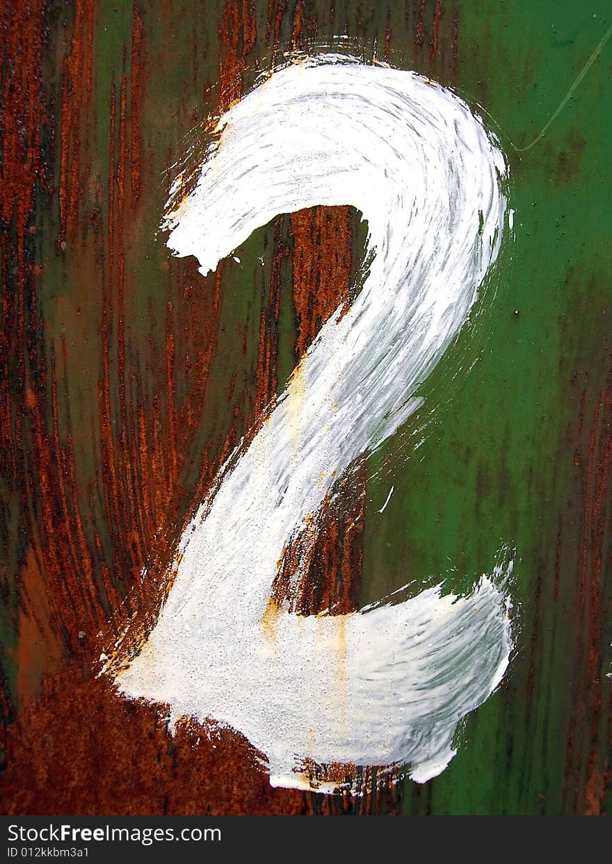 The figure two is drawn by a white paint  on a rusty metal background.