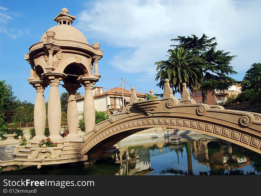 The fishpond with a bridge and a small temple in the park of Grock's Villa in Imperia, Liguria in Italy. 
Grock was the name of art of Adrien Wettach, the most famous clown of XX century. Grock was born in Reconvilier (Switzerland) in 1880 and he was consecrated Clown's King at the Olympia in Paris in 1919. He died in Imperia in 1958. The fishpond with a bridge and a small temple in the park of Grock's Villa in Imperia, Liguria in Italy. 
Grock was the name of art of Adrien Wettach, the most famous clown of XX century. Grock was born in Reconvilier (Switzerland) in 1880 and he was consecrated Clown's King at the Olympia in Paris in 1919. He died in Imperia in 1958.