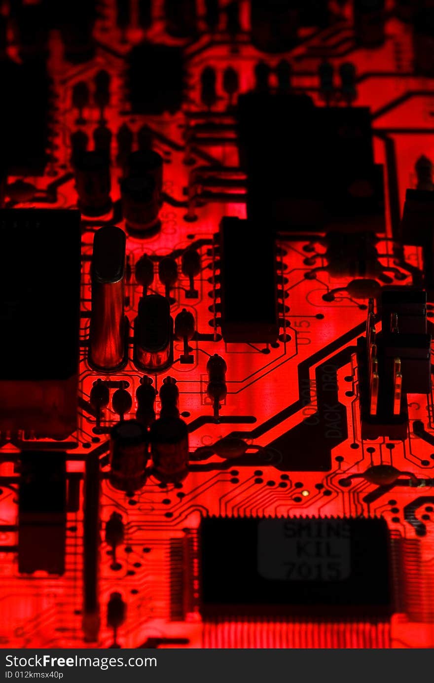 Red circuit board closeup lit from below through the board, creating a unique glow effect. Red circuit board closeup lit from below through the board, creating a unique glow effect.