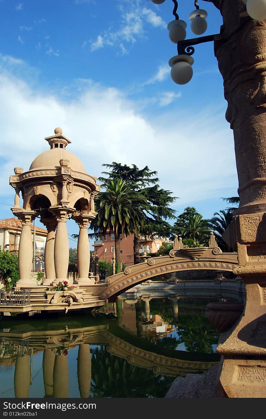 The fishpond with a bridge and a small temple in the park of Grock's Villa in Imperia, Liguria in Italy. 
Grock was the name of art of Adrien Wettach, the most famous clown of XX century. Grock was born in Reconvilier (Switzerland) in 1880 and he was consecrated Clown's King at the Olympia in Paris in 1919. He died in Imperia in 1958. The fishpond with a bridge and a small temple in the park of Grock's Villa in Imperia, Liguria in Italy. 
Grock was the name of art of Adrien Wettach, the most famous clown of XX century. Grock was born in Reconvilier (Switzerland) in 1880 and he was consecrated Clown's King at the Olympia in Paris in 1919. He died in Imperia in 1958.