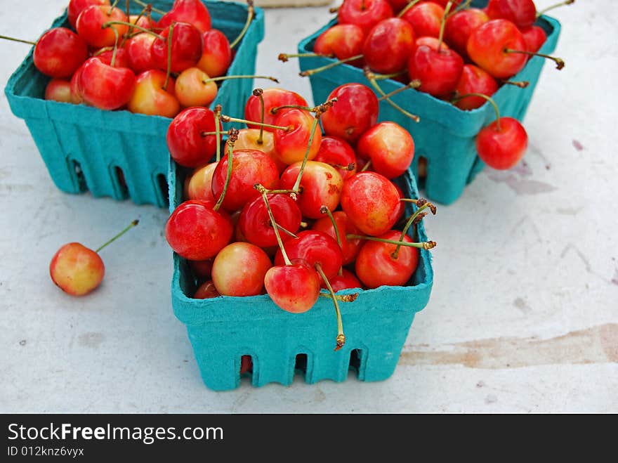 Bright colored cherries in turquoise disposable boxes. Bright colored cherries in turquoise disposable boxes.