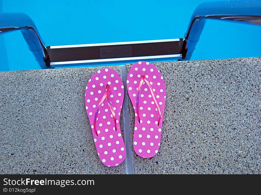 Bright flip-flops at the top of the pool ladder. Bright flip-flops at the top of the pool ladder.