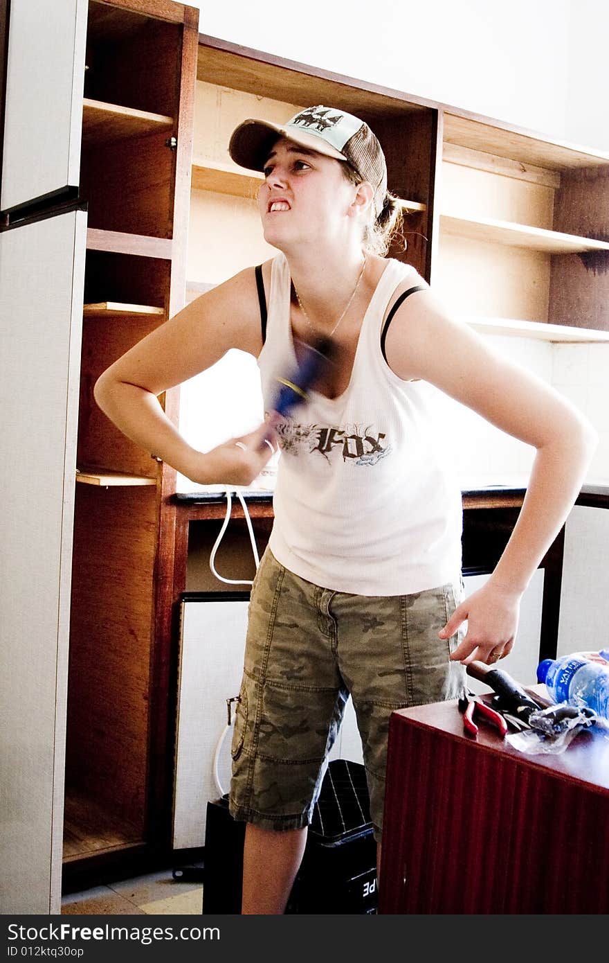 Woman repairing and renovating kitchen cupboard. Woman repairing and renovating kitchen cupboard