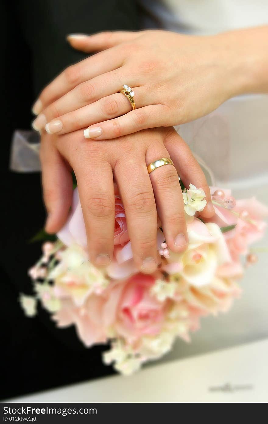 Hands of bride and groom with rings on bouquet. Hands of bride and groom with rings on bouquet.