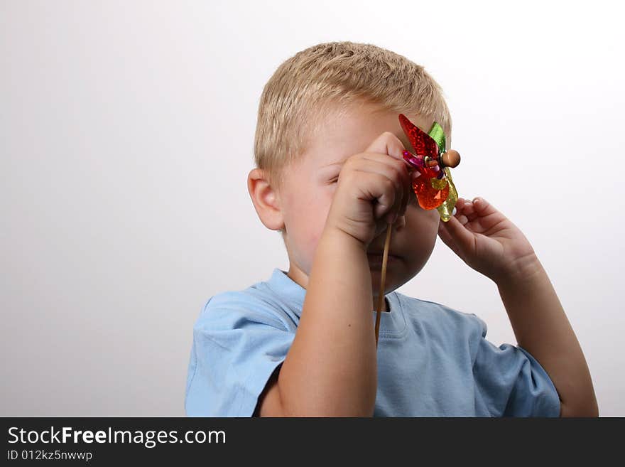 Toddler hiding behind his foil wind fan. Toddler hiding behind his foil wind fan