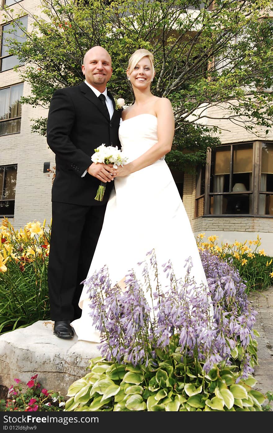 An just married couple standing on a big rock for photo shoots. An just married couple standing on a big rock for photo shoots.