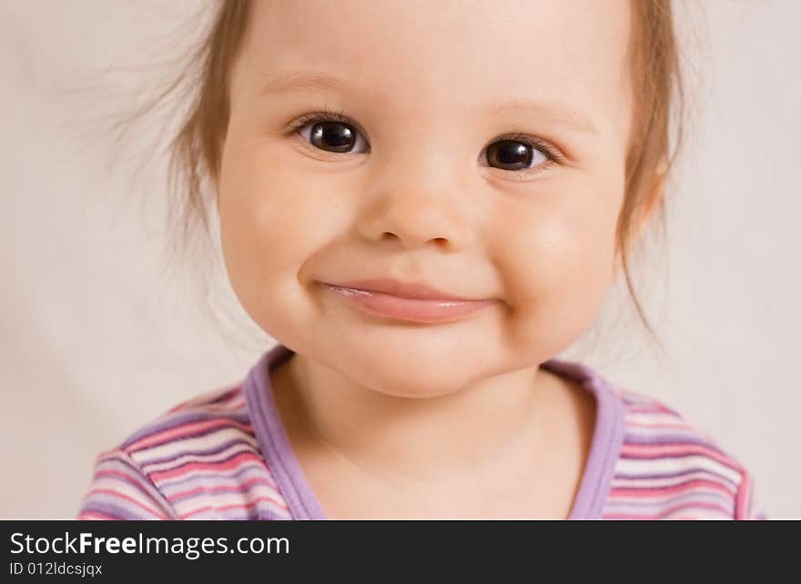 Small joyful smiling girl in rose shirt