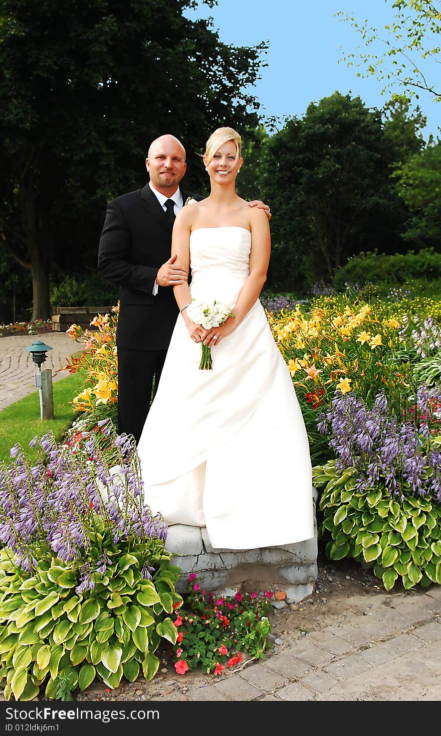 An just married couple standing on a big rock for photo shoots. An just married couple standing on a big rock for photo shoots.