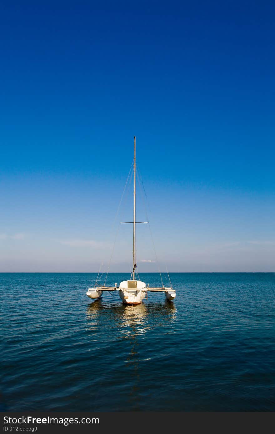 Lonely boat floating on blue calm see. Lonely boat floating on blue calm see