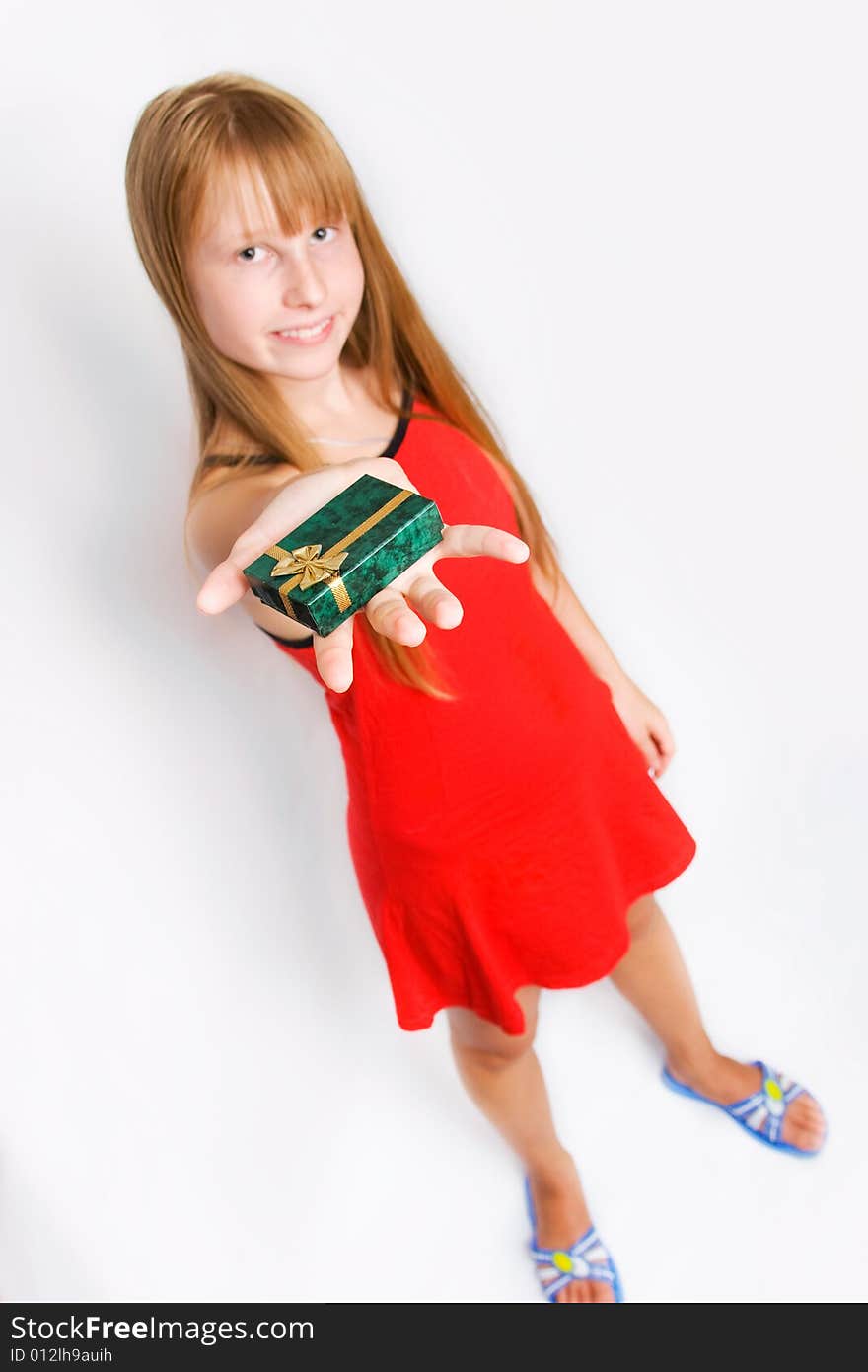 Pretty teenager girl in red dress holding gift box