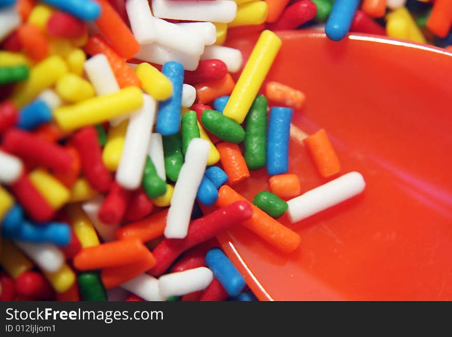 Plastic spoon in a bowlful of sprinkles