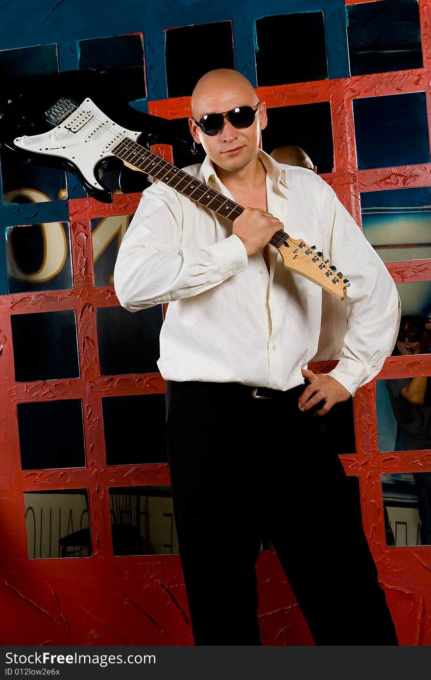 Man with electric guitar in night club