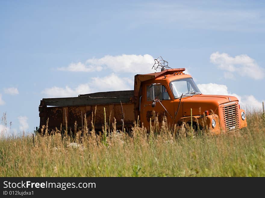 Old run-down pick-up truck abandoned in a field