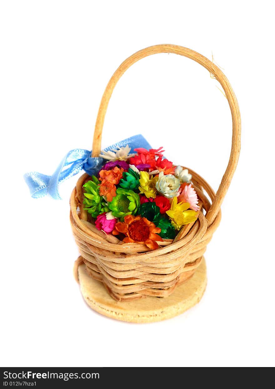 Artificial colorful flowers in a basket on a white background