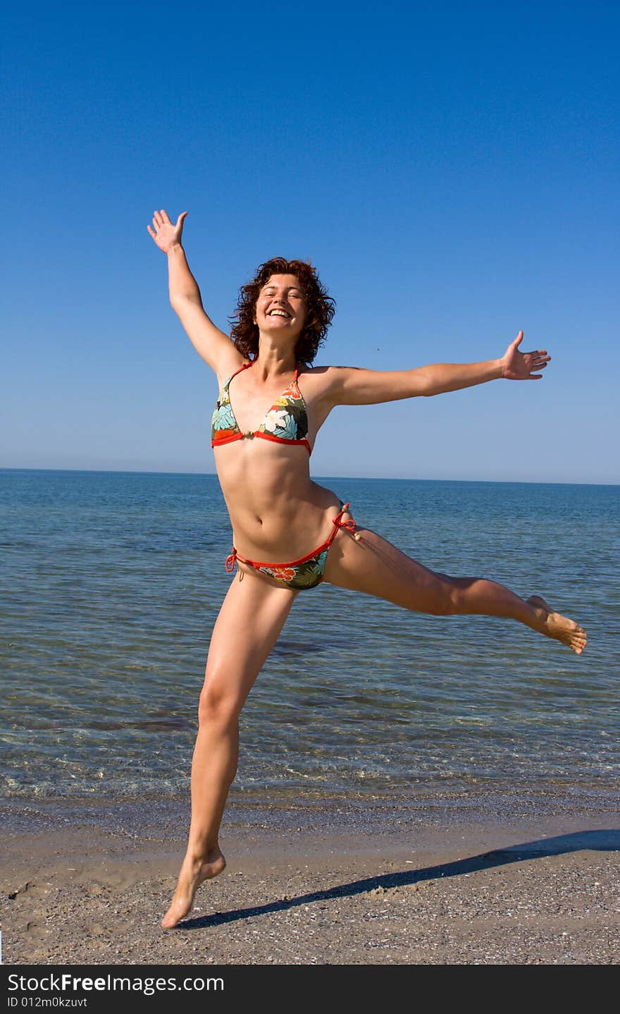 Happy Smiling Girl Jumping At Sea Beach