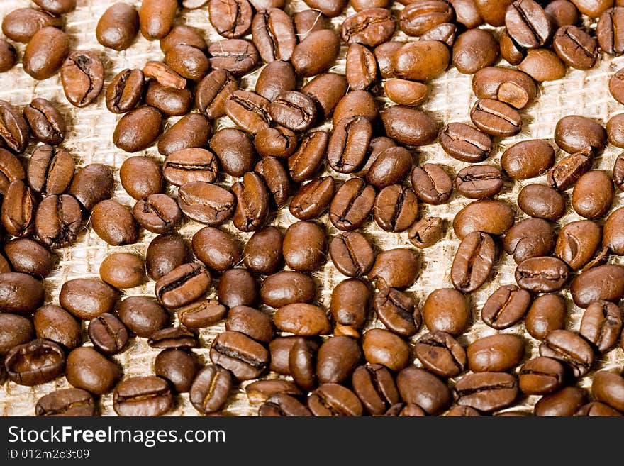 Coffee beans background on the textile jute canvas