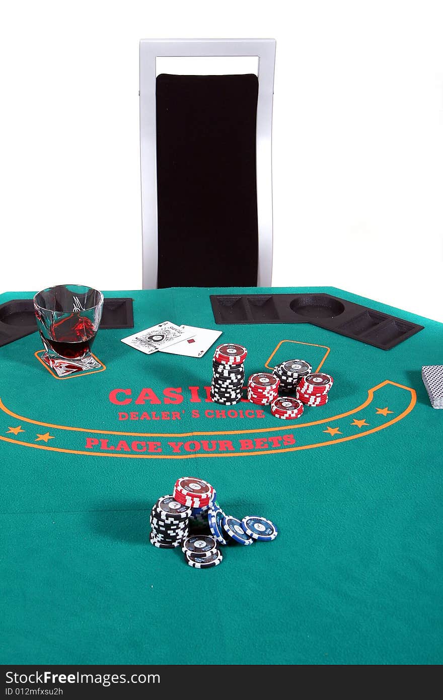 A poker table with chips a drink and cards. A chair invites to sit down. Isolated over white.