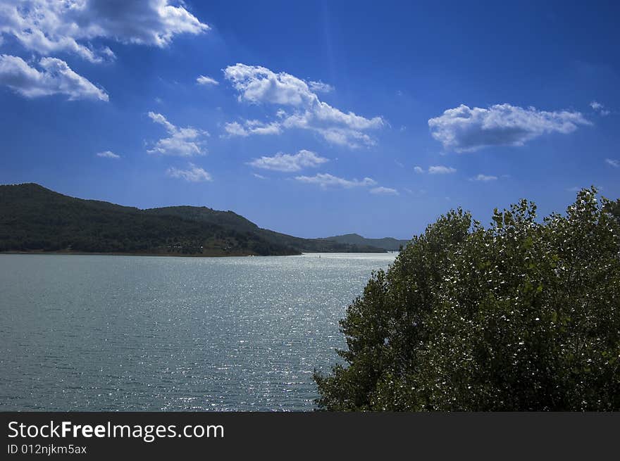 Lake in mountain with blue sky and fluffy white clouds