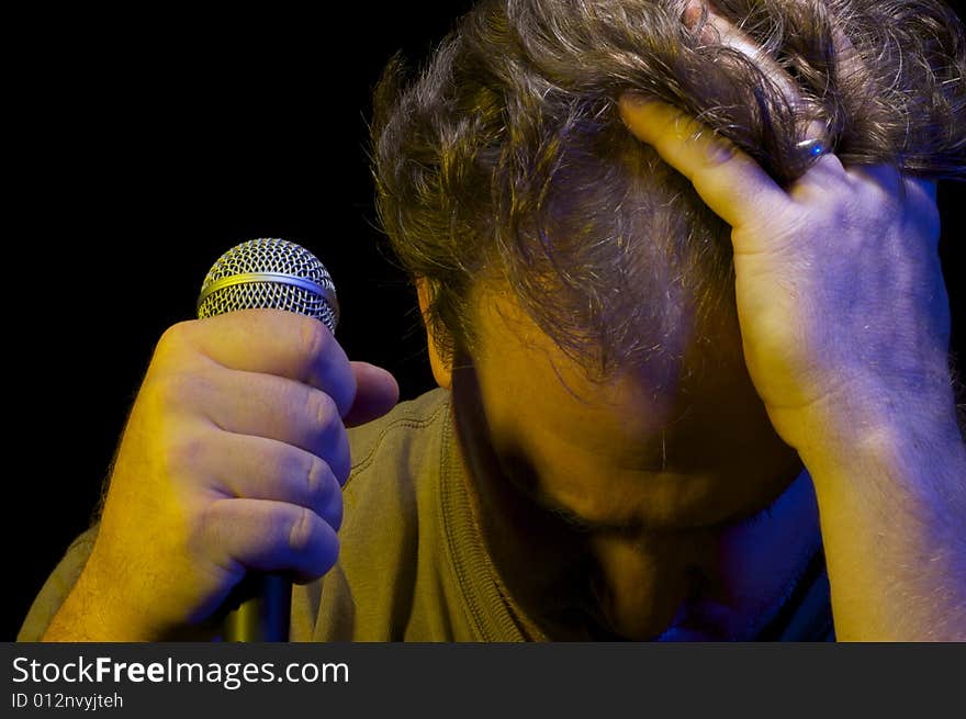 Passionate Vocalist with Microphone on a black background. Passionate Vocalist with Microphone on a black background.