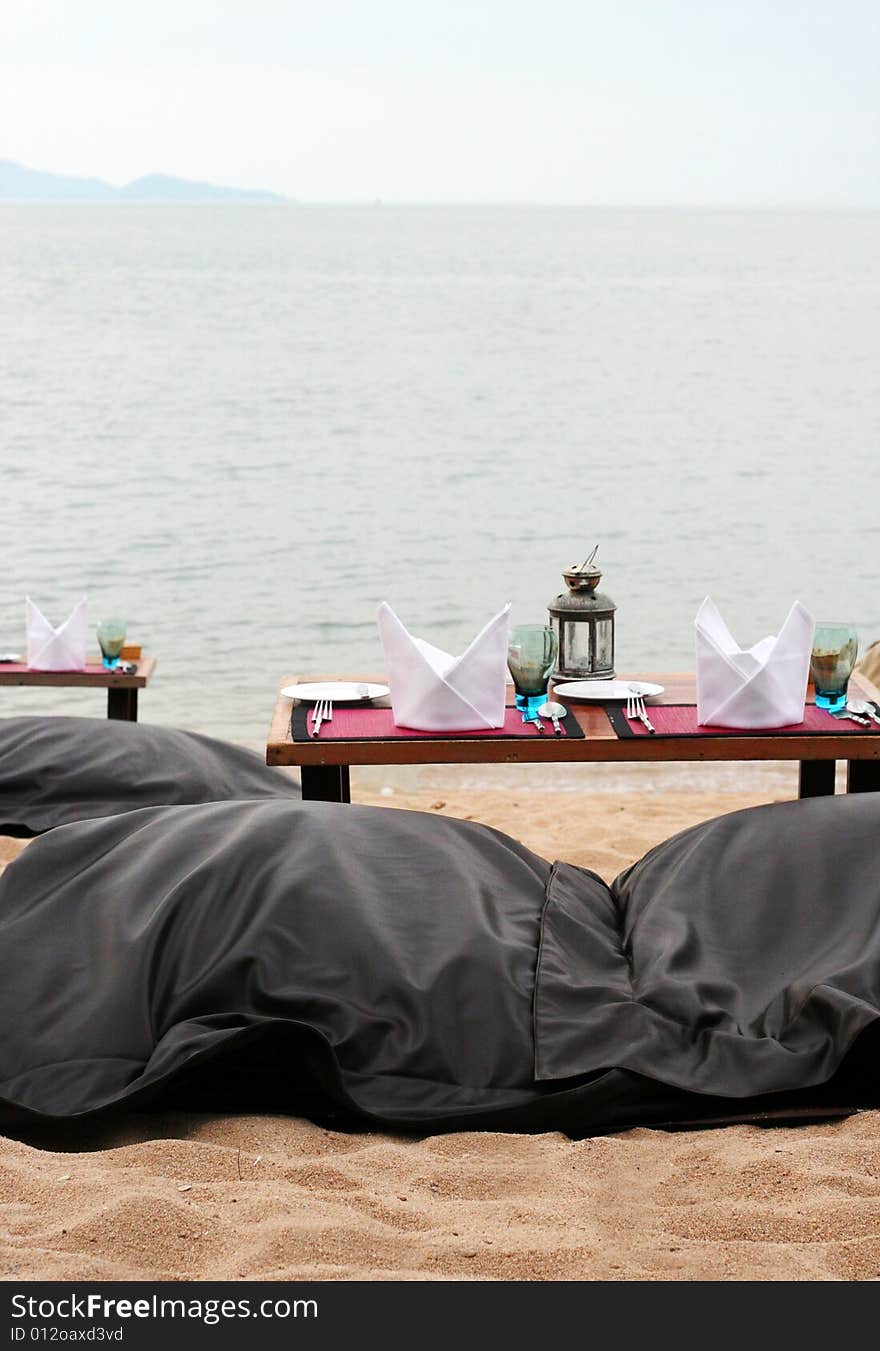 Romantic table setting on a sandy beach.