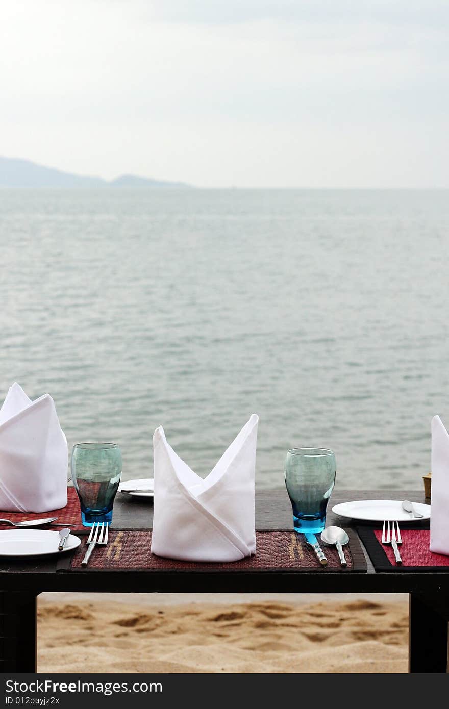 Romantic table setting on a sandy beach.